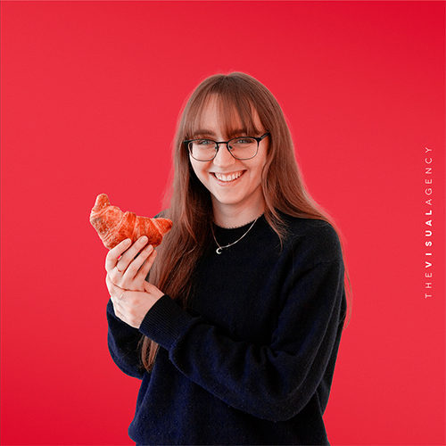 Francesca Gheli is a Digital Designer. She's holding a croissant like it’s her secret weapon for pixel-perfect mornings.